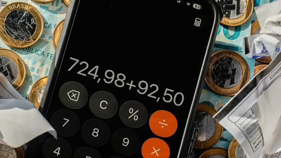 Notas e moedas de real sobre uma mesa