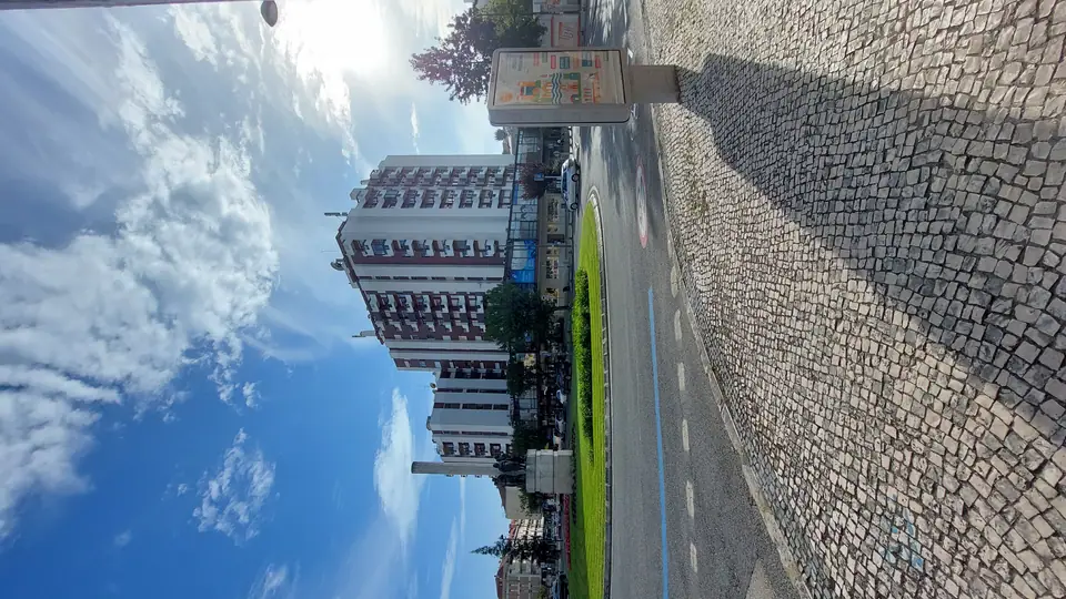 Centro comercial visto de avenida arborizada em Maringá