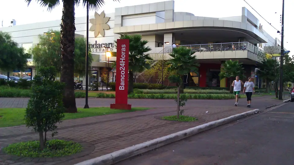 Rua comercial em Maringá com estabelecimentos e veículos