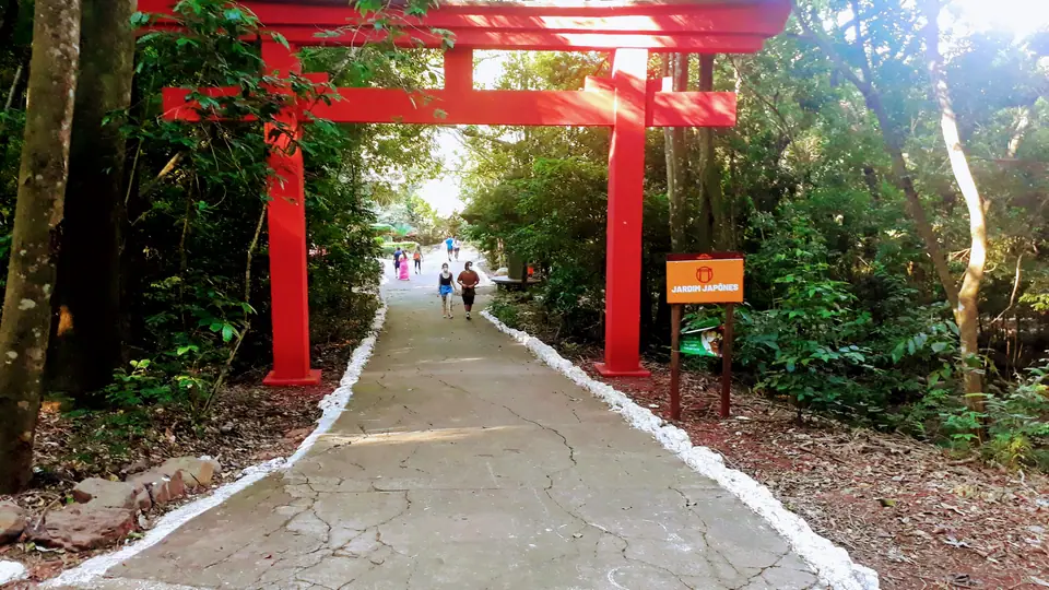 Jardim arborizado em parque de Maringá sob céu aberto