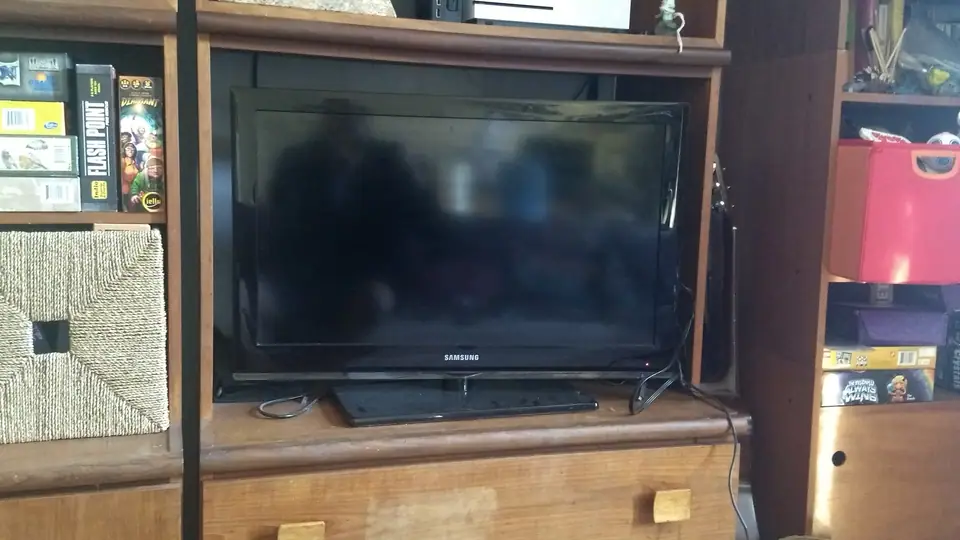 Televisor de tela plana ligado em ambiente escuro